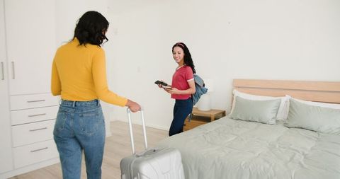 Mother and Daughter Packing for Family Trip in Cozy Bedroom