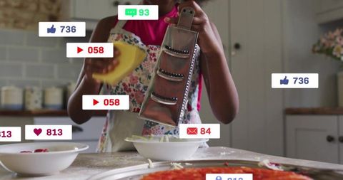 Young girl grating cheese in floral apron at kitchen counter with social media badges