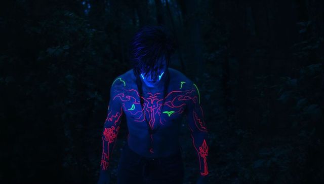 Tribal Luminescent Body Art in Nocturnal Forest