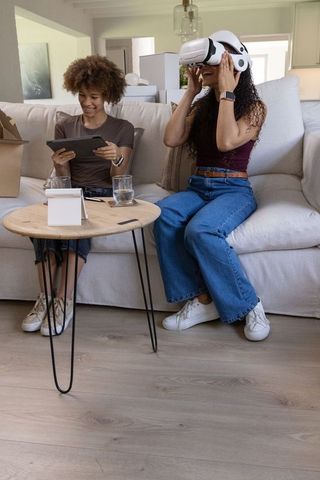 African american friends trying virtual reality headset while unpacking in living room