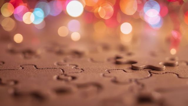 Puzzle Piece Rising with Festive Colored Bokeh in Background