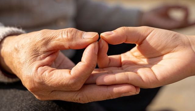 Senior hand passing seed to younger palm conveying care and intergenerational connection