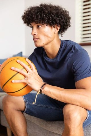 Athletic Man Relaxing with Basketball in Modern Living Room