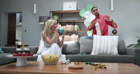 Couple Preparing for Celebration at Home with Balloons and Snacks