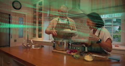 Chinese couple cooking together at kitchen island preparing meal with fresh ingredients
