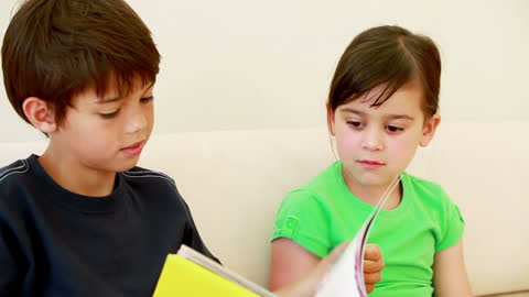 Kids Reading Together on Sofa in Bright Room