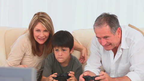 Grandparents Bonding with Grandson Playing Video Games at Home