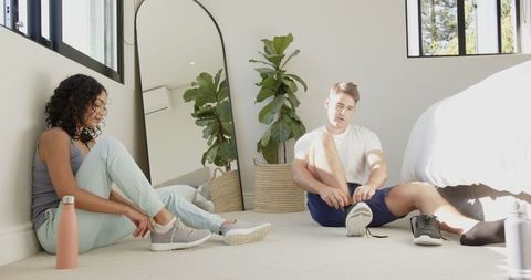 Couple preparing for exercise in bright bedroom