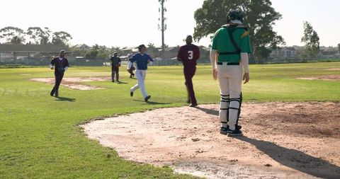 Baseball Players Running Toward Home Plate on Sunny Day