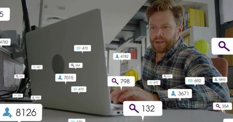 Middle-aged man typing on laptop in office with floating social and analytics overlays