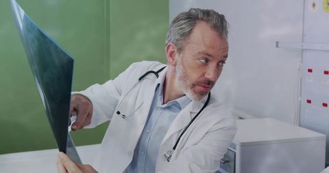 Senior Doctor Analyzing Patient X-ray in Examination Room