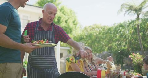 Family Enjoying Garden Barbecue Gathering Outdoors