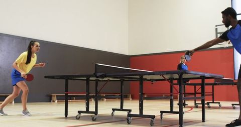 Energetic Teammates Engaged in Intense Table Tennis Match