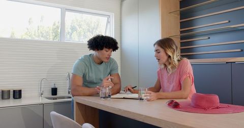 Young Couple Strategizing Plans at Modern Kitchen Counter