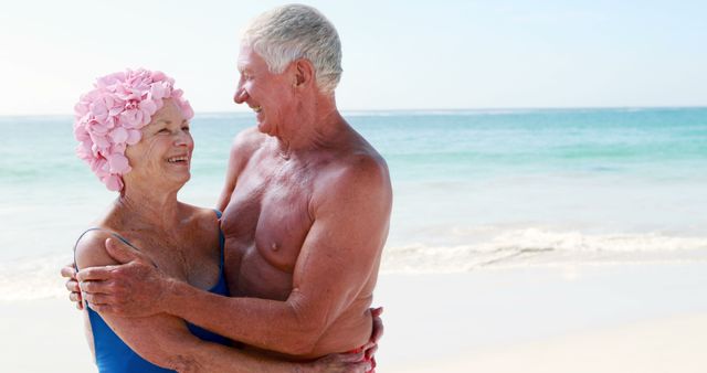 Senior couple enjoying time together at the beach, laughing and bonding. Ideal for themes of love, retirement, leisurely lifestyle, and vacation. Can be used in promotional materials for travel agencies, retirement communities, and health and wellness campaigns.