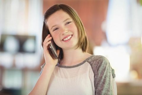 Teen Girl Smiling During Phone Conversation in Bright Home Interior - Download Free Stock Images Pikwizard.com