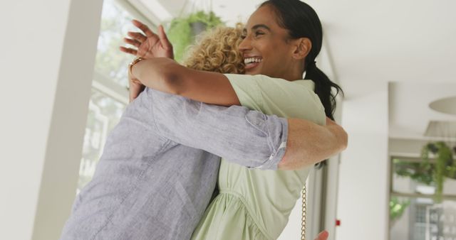 Two women hugging and smiling in bright indoor setting - Download Free Stock Images Pikwizard.com