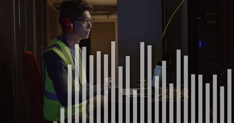 Data technician monitoring servers with graph overlay in data center