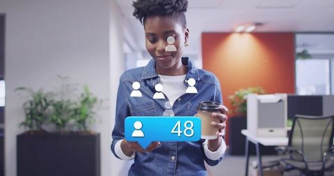 Young professional checking smartphone with follower notification while holding coffee cup