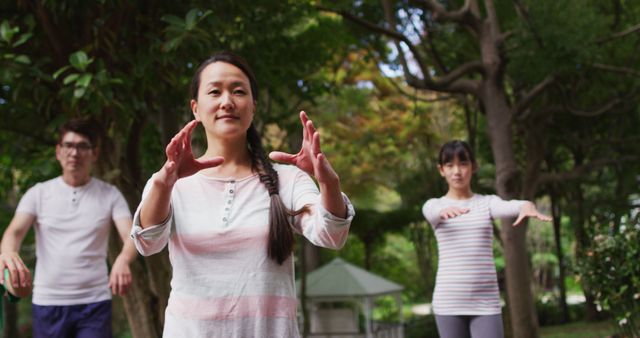 Happy asian parents exercising in garden with son and daughter, practicing tai chi together. happy family, at home in isolation during quarantine lockdown.