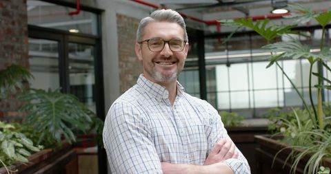 Smiling Professional in Modern Office with Lush Green Plants
