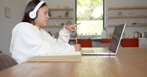 Teen Girl Focused on E-learning with Laptop and Headphones at Home