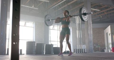 Focused Female Athlete Lifting Barbell in Industrial Gym - Download Free Stock Images Pikwizard.com