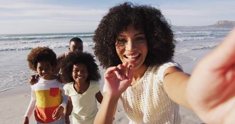 Smiling Family Enjoying Beach Day and Capturing Selfie