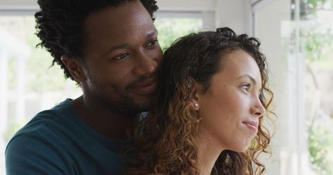 Affectionate couple embracing by sunlit window