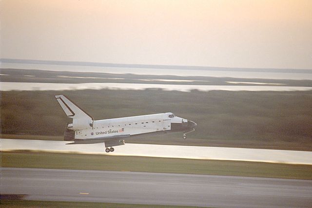 This depicts the Space Shuttle Endeavour landing at Kennedy Space Center's Shuttle Landing Facility on Runway 33 after the STS-99 mission. Caption suggests it is February 2000 at sunset. Useful for illustrating space exploration history, aerospace technology, and NASA missions. Ideal for educational materials, articles on space exploration, and science presentations.