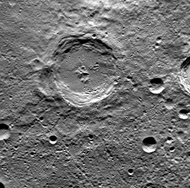 High-resolution image of Dickens Crater located on the surface of Mercury, captured by the MESSENGER spacecraft. Scientists use this data to study Mercury's surface morphology and geological features. Useful for educational purposes, articles on planetary science, or for illustrating space exploration missions such as those conducted by NASA.