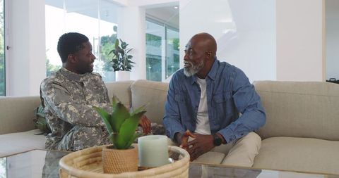 Father and Soldier Son Sharing Emotional Conversation on Sofa