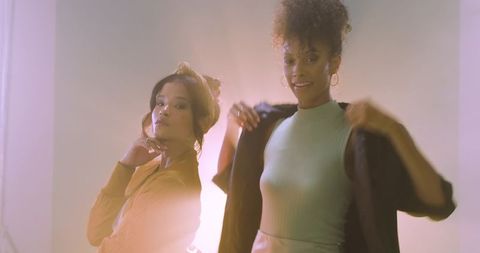 Modern Duo Fashion Portraits: Diverse Women Posing with Hoops, Scarves and Backlit Glow