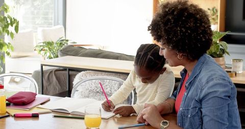 Mother Assisting Daughter with Homework in Modern Living Room