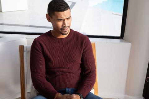 Man Pondering by Poolside Window in Modern Home Interior