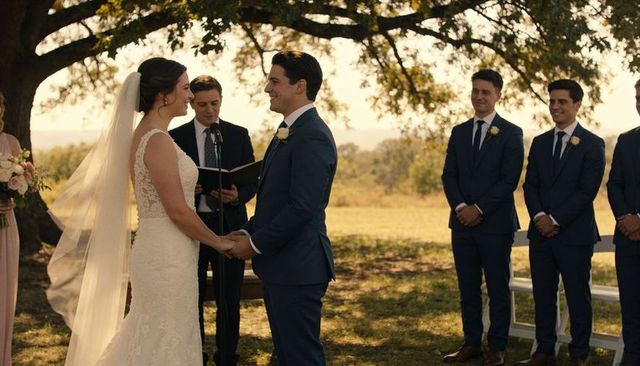 Outdoor rustic wedding couple exchanging vows under oak tree bride in lace gown and veil
