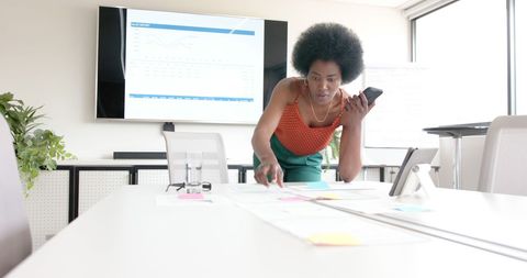 Businesswoman in Office Communicating on Phone Near Documents