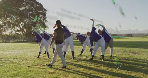 Baseball coach leading team stretch in outdoor sunset session