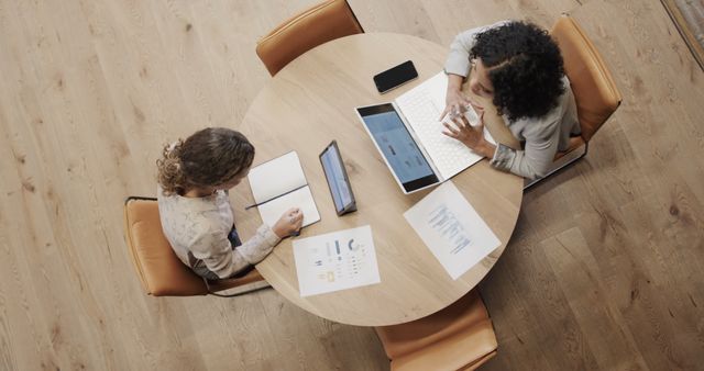 Top View of Business Meeting with Two Women Using Laptop and Tablet - Download Free Stock Images Pikwizard.com