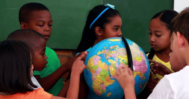 Diverse group of children learning geography with globe in classroom - Download Free Stock Images Pikwizard.com