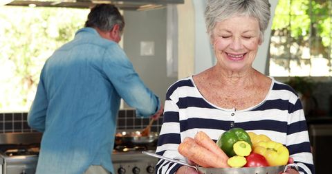 Senior Couple Enjoys Preparing Fresh Salad Together at Home