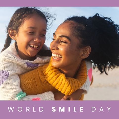 Happy mother and daughter celebrating world smile day outdoors
