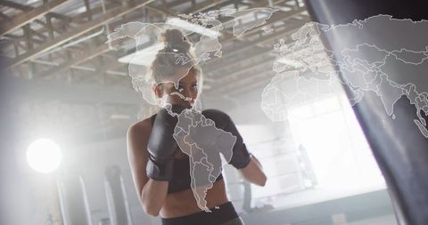 Female boxer training with world map overlay in industrial gym for global fitness concept