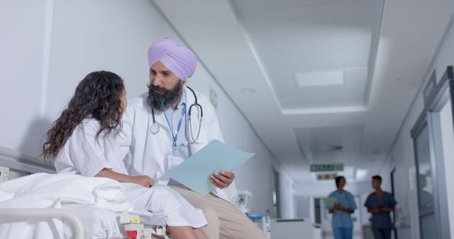 Doctor with Young Patient Discussing Medical Records in Hospital Corridor - Download Free Stock Images Pikwizard.com