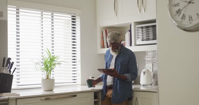 Retired Man Enjoying Coffee and Digital Tablet in Modern Kitchen - Download Free Stock Images Pikwizard.com