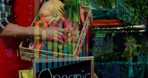 Vendor holding wicker basket of fresh organic vegetables with market charts overlay