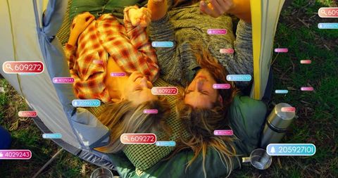 Couple lying in tent surrounded by ar tags enjoying cozy camping morning