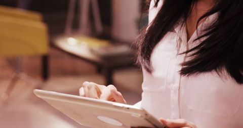 Professional Woman Tapping Tablet in Modern Workspace