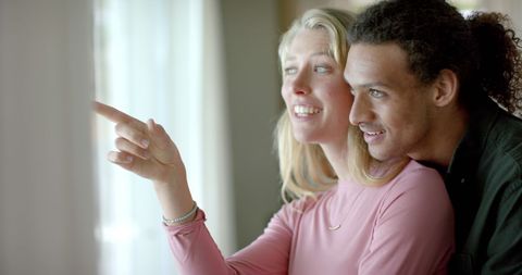 Happy Diverse Couple Embracing and Smiling Indoors