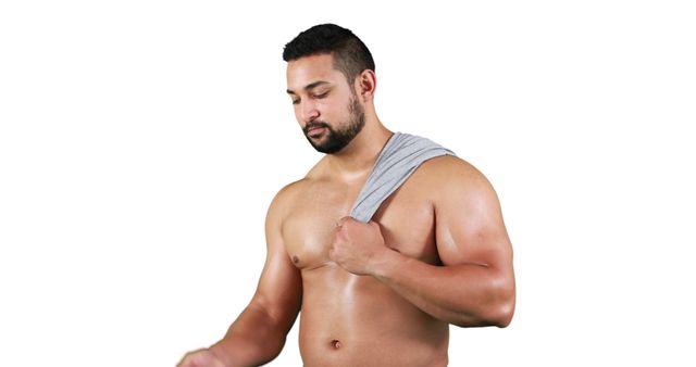A muscular man with a fit physique holds a towel over his shoulder, appearing thoughtful and focused. Ideal for use in fitness, health, and wellness contexts, illustrating gym routines, strength conditioning, or physical health maintenance.